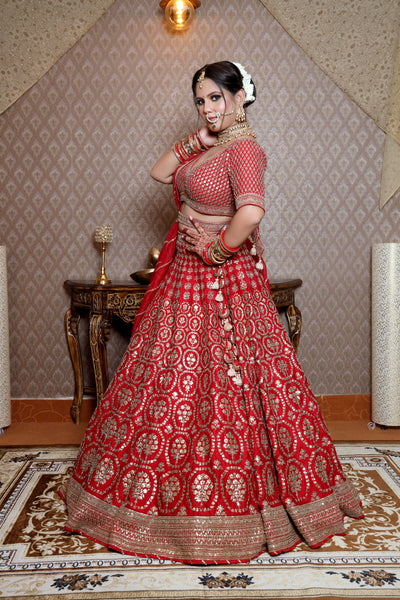 woman side posing wearing red raw silk lehenga