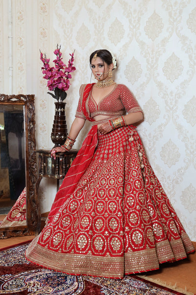 model posing wearing red raw silk lehenga