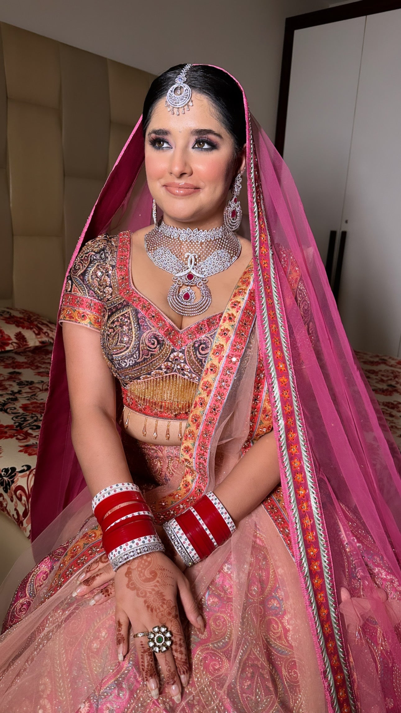 model posing wearing rani pink raw silk lehenga