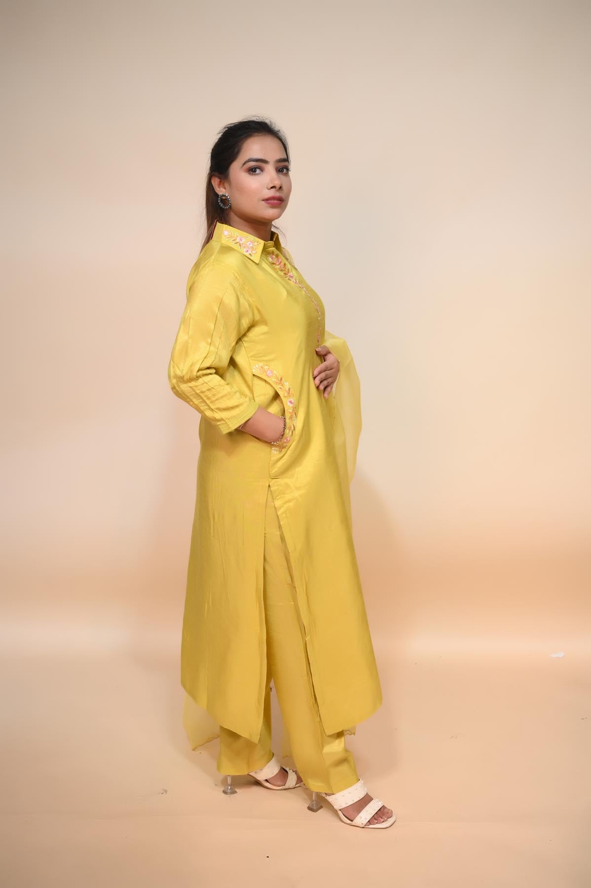model side posing in light yellow crepe suit