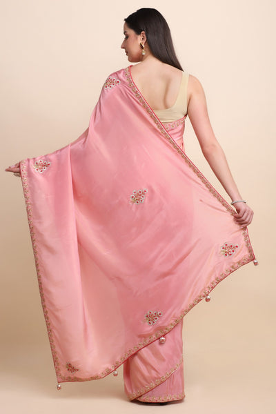 woman showing back of pink embroidered saree