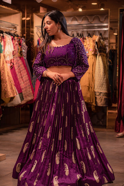 model posing wearing purple paisley motif lehenga