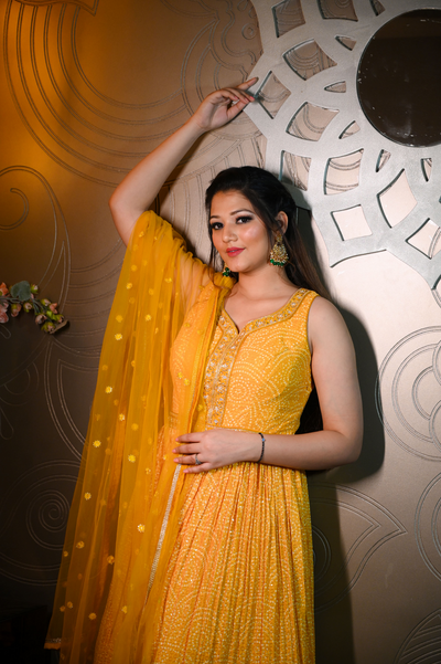 model posing in yellow bandhej dress